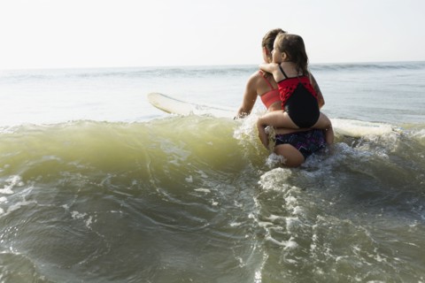 Mother and daughter surfing in waves