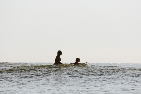Mother and daughter surfing in waves