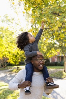 Father carrying son on shoulders outdoors