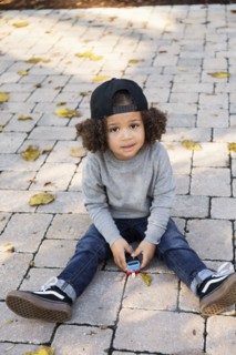 Mixed race boy sitting on brick patio
