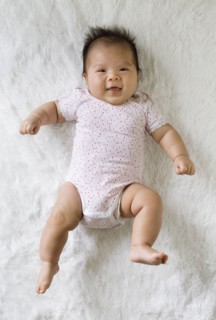 Mixed race baby girl laying on floor