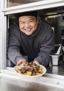 Proud Asian man showing bowl of food at food truck