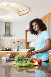 Black woman chopping vegetables in kitchen