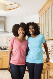 Black mother and daughter hugging in kitchen
