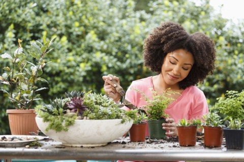 Black woman gardening at table outdoors