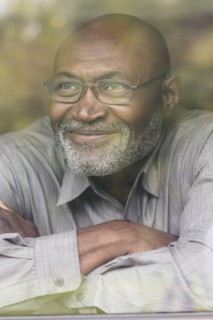 Smiling Black man behind window