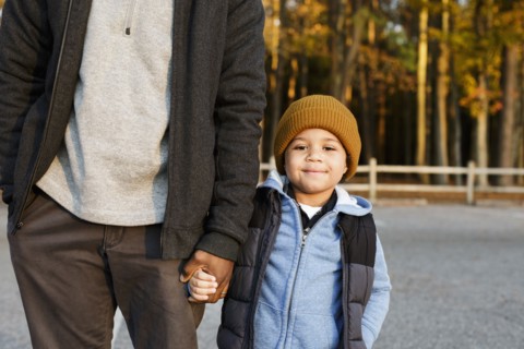 Father and son holding hands in park