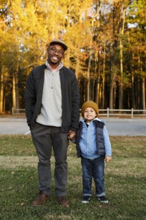 Father and son holding hands in park
