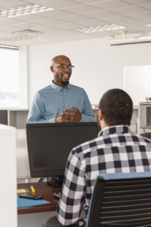 Men talking in office near computer