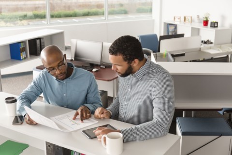 Men reading paperwork in office