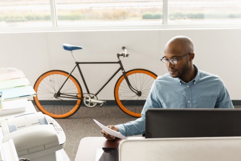 African American man reading paperwork in office