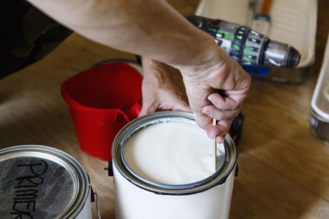Hand of native American woman stirring paint