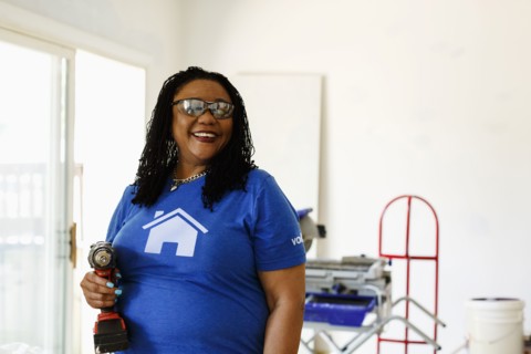 Black volunteer woman holding drill