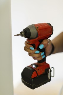 Hand of black woman holding drill