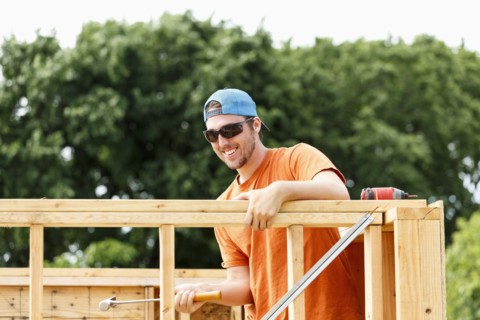 Caucasian man hammering at construction site