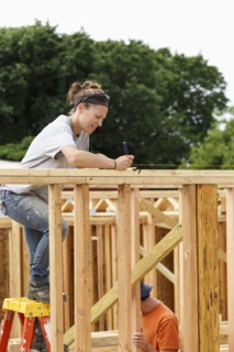 Caucasian woman measuring at construction site