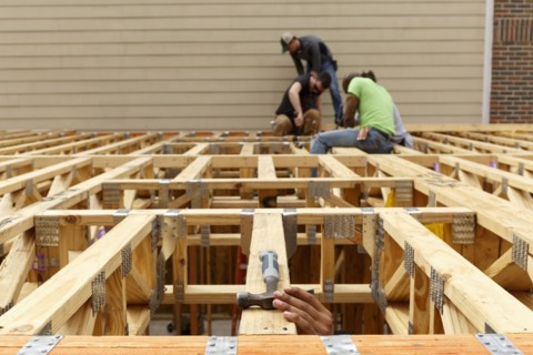 Hand reaching for hammer on the roof at construction site