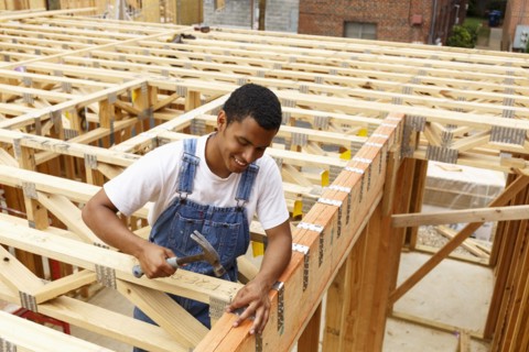 Mixed race man hammering nail at construction site