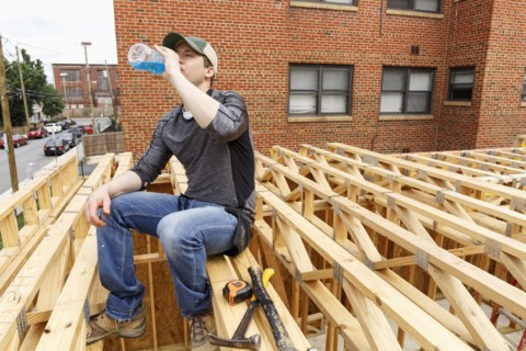 Caucasian man drinking beverage at construction site