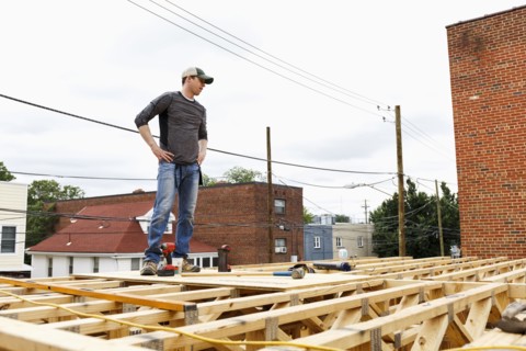 Caucasian man standing on the roof construction site