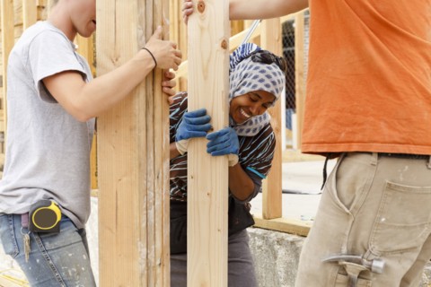 Volunteers holding lumber at construction site
