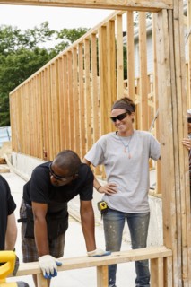 Volunteers holding frame at construction site