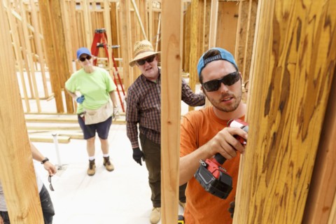 Volunteer using drill at construction site