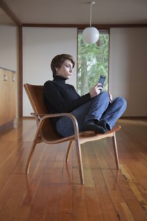 Caucasian woman using cell phone in armchair