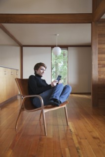 Caucasian woman using cell phone in armchair