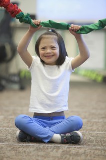 Mixed race Down syndrome girl playing with rope