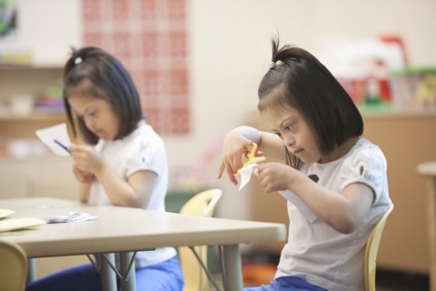Mixed race students with Down syndrome in classroom