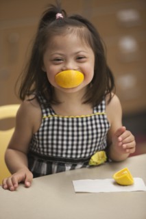 Mixed race girl with Down syndrome eating fruit
