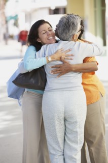 Three women hugging outdoors