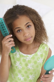 Young African American girl brushing hair