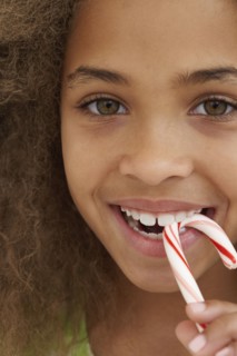 Close up of African American girl eating candy cane
