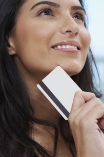 Close up of Hispanic woman holding credit card