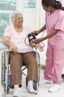 Nurse taking senior woman's blood pressure