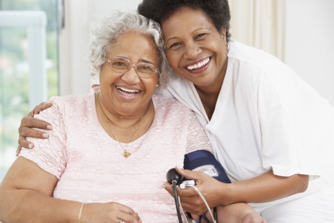 African American mother and adult daughter smiling at each other