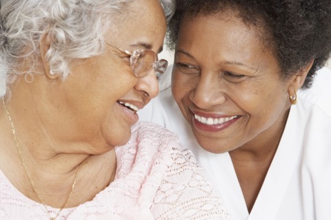 African American mother and adult daughter smiling at each other