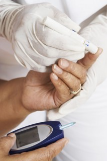 African American woman having blood sugar tested