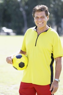 Hispanic man holding soccer ball