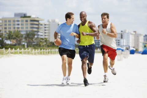 Multi-ethnic men running in beach