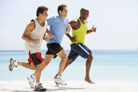 Multi-ethnic men running in beach