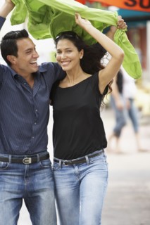 Couple holding raincoat over heads