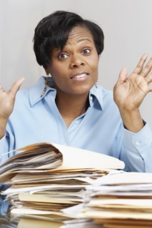 African businesswoman behind stacks of folders