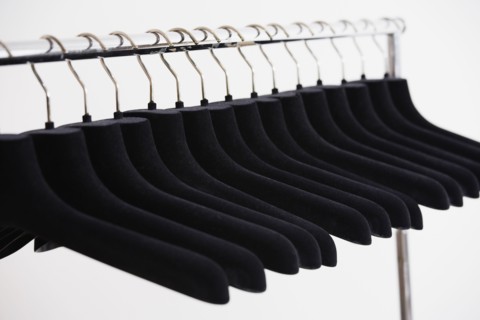 Row of empty clothing hangers on rack