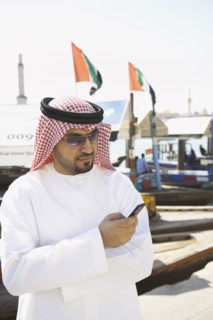 Arab man text messaging on cell phone