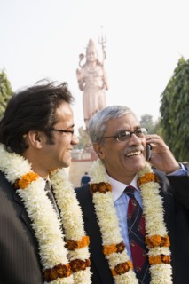 Indian businessmen wearing floral necklaces at tourist attraction