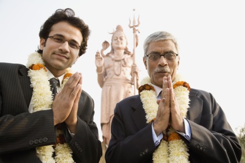 Indian businessmen wearing floral necklaces at tourist attraction