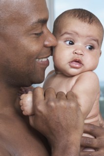 African father holding baby daughter
